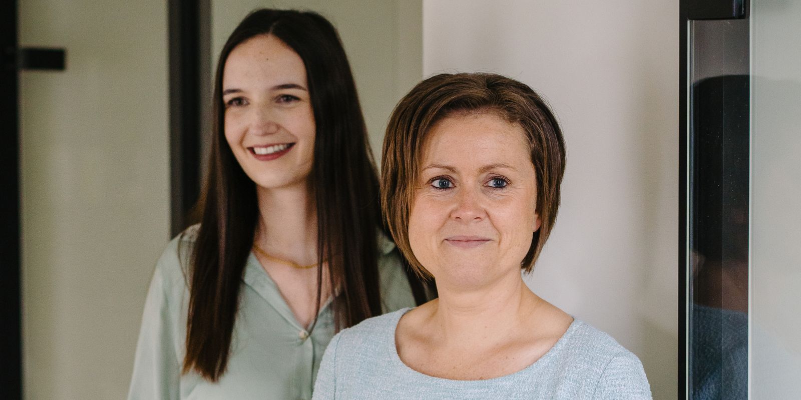 Een close-up beeld met advocaat Tina Devlamynck op de voorgrond en advocaat Helena Debaere achter haar.